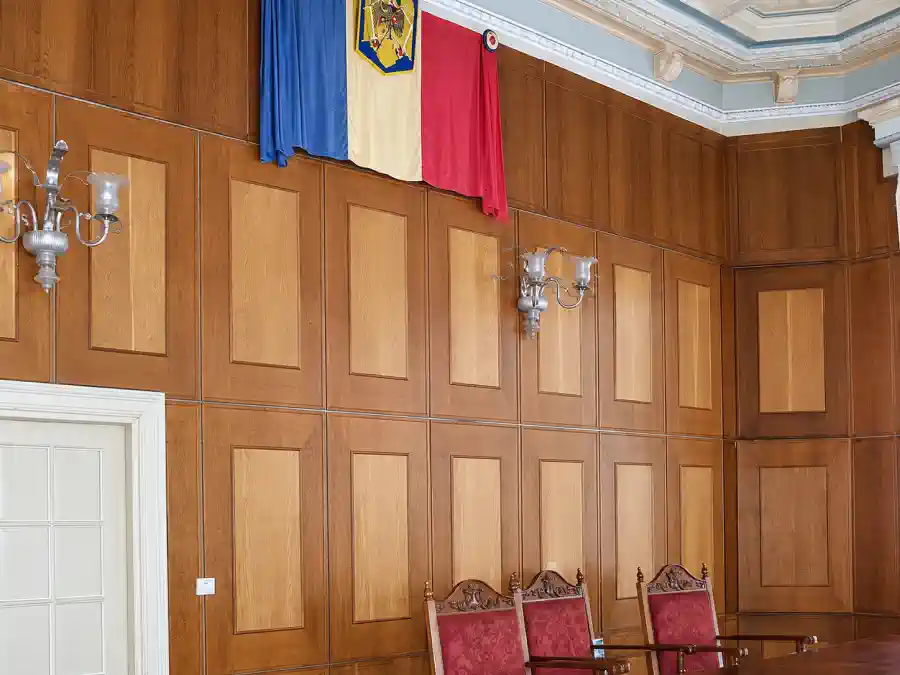 Archivaufnahme des aktiven Gerichtssaals in der Casa Băileșteanu mit rumänischer Flagge und Wandverkleidung