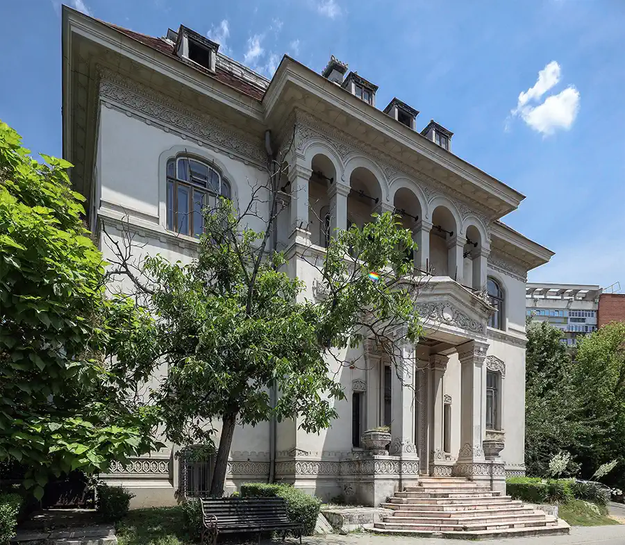 Fassade der Casa Băileșteanu in Craiova mit Rundbogenloggia, ornamentalen Stuckfriesen und repräsentativer Freitreppe